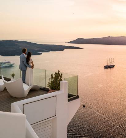 couple in love on romantic location - luxury hotel in greece overlooking the caldera of greek island santorini terrace with seaview vacation honeymoon
